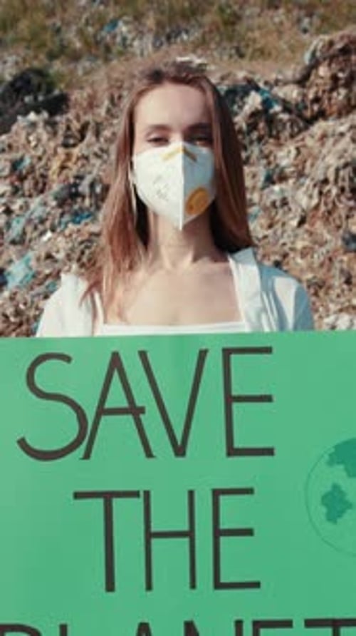 Woman Holds Save the Planet Sign Near Landfill