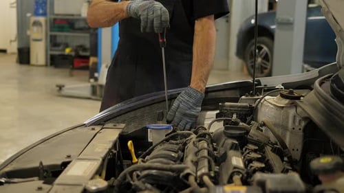 Mechanic Working on Car Engine in Garage