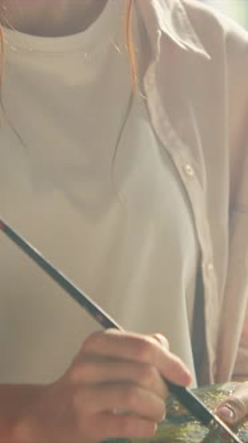Woman Mixing Paint with Brush on Palette