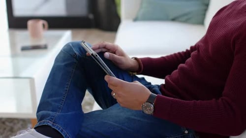 Young Man Using Tablet on Sofa Indoors
