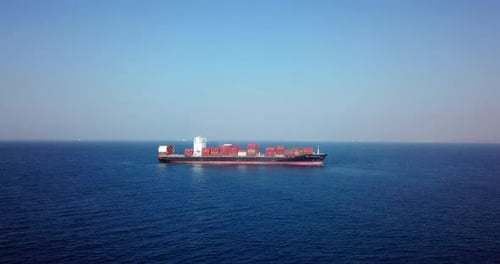 Large loaded container Ship cruising slowly at Sea, Aerial view