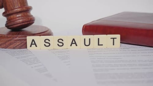 Gavel, Book, and "Assault" Tiles on Legal Document