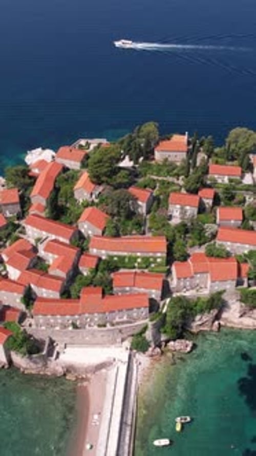 Vertical Drone Shot of Sveti Stefan Island, Luxury Resort in Montenegro, Stone Houses and Tombolo