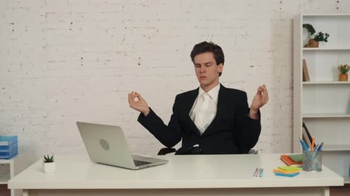Young Adult Meditating at Desk in Office