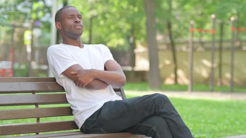 Young Man Contemplating on a Park Bench