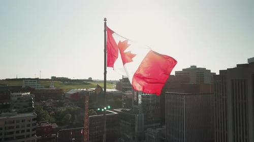 Canadian Flag Waving Over Urban Cityscape