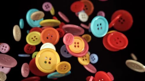Multicolored Sewing Buttons Fly on a Black Background Filmed on a Highspeed Camera at 1000 Fps