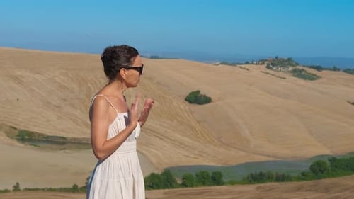 Une femme ne se sent pas bien sur fond de collines vallonnées de la Toscane