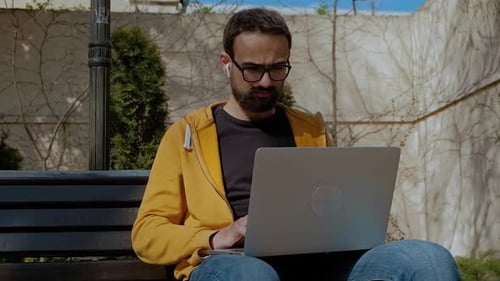 Männer, die mit seinem Laptop auf der Straße aus der Ferne arbeiten