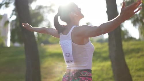 Woman Celebrates Marathon Victory in Sunny Park