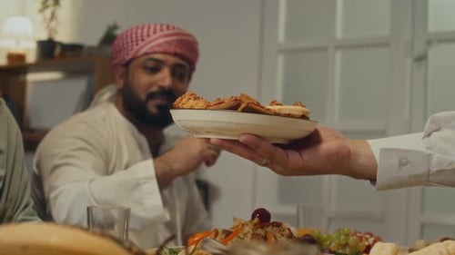 Hospitable Host Sharing Pasty with Family Members on Eid al-Fitr