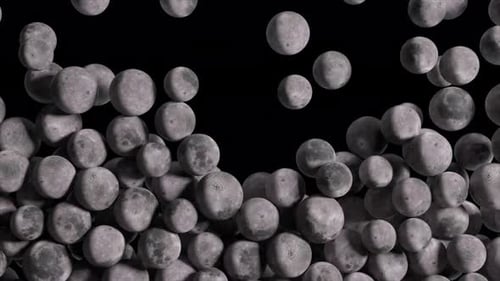 Kleine sphärische Monde mit sichtbaren Kratern fallen von oben, sammeln sich an, füllen den Rahmen und dann