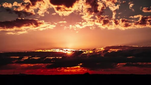 Timelapse of Dramatic Sunset in the Orange Sky Through Layered Clouds