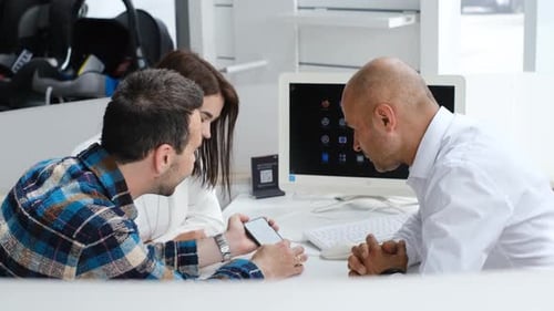 A Happy Young Couple Signs a Bank Loan Agreement with a Real Estate Agent to Buy a House