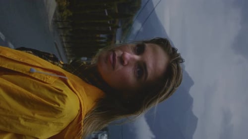 Woman in Yellow Raincoat with Mountains