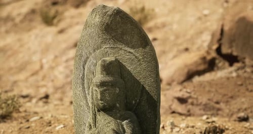 Ancient Stone Carving Amid Sand and Stones in a Dry Landscape