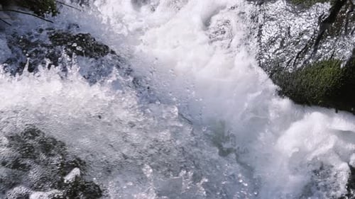 Ultra Slow Motiion Waterfall Flowing Along Powerful River with Details of Water Droplets