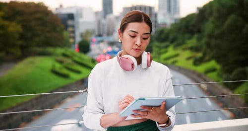 Young Woman Using Tablet on Urban Bridge