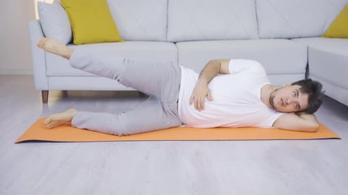 Man working out his leg muscles. Sports at home.