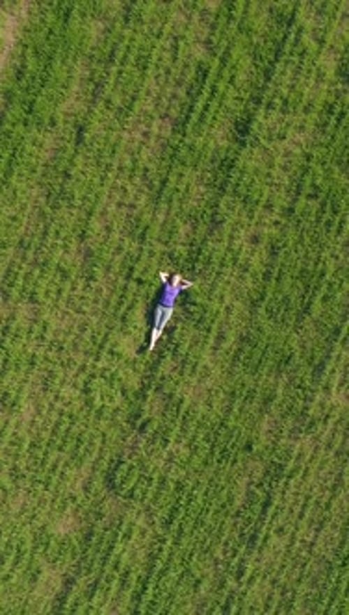 Young Woman is Relaxing on Huge Green Lawn Drone is Spinning Around and Flyi Vertical Video