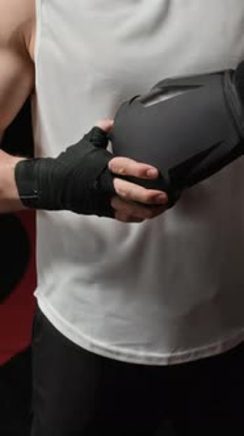 Man Wrapping Hands with Boxing Wraps and Gloves