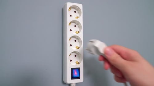 Hand Plugs Electrical Cord Into Extension Cord