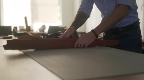 Leather Craftsman Works in His Workshop Master Making Leather Products Man Takes Leather Bundle Puts