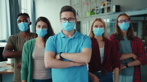 A Diverse Group of Professionals Wearing Masks in an Office Setting for Safety and Health
