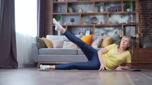 Mature Woman Doing Leg Raises on a Mat