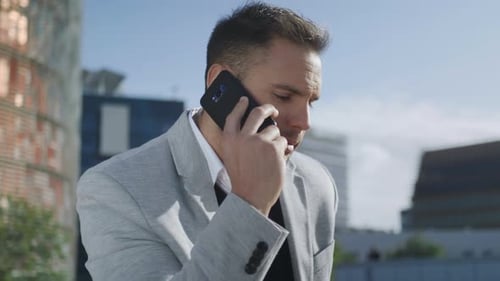 Closeup Serious Businessman Having Phone Conversation at Street. Confident Business Man Talking