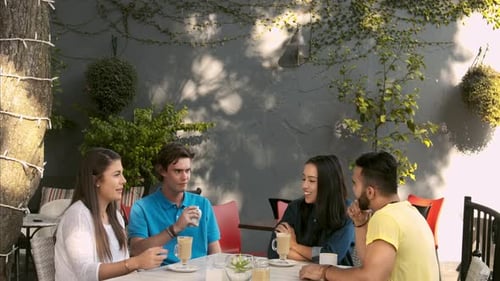 Friends Enjoying Coffee and Conversation at Outdoor Cafe
