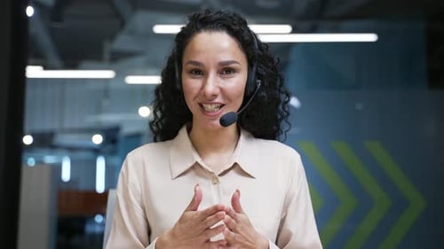 Webcam view. Confident businesswoman in wireless headset talking on a video call looking at camera