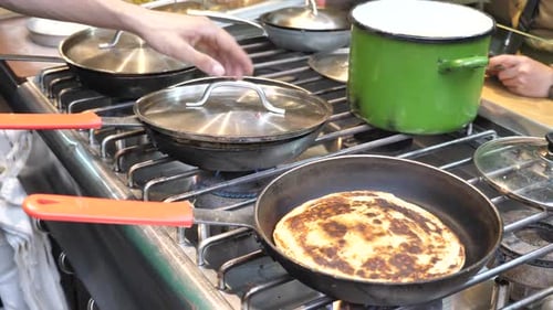 Man Cooking Flatbread on Industrial Kitchen Stove