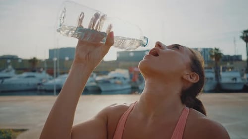 Young Adult Drinks Water on Sunny Day by Marina
