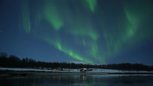 winter scenery with small cozy cabin and northern lights (aurora borealis) above in the landscape of