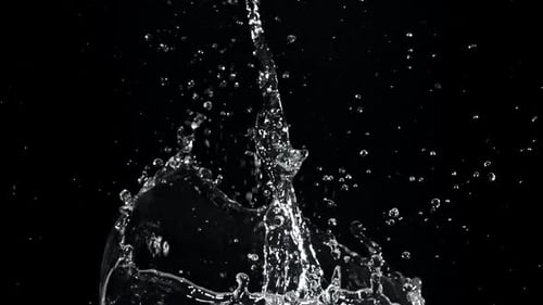 Clear water splashing against a black background in studio