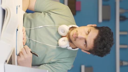 Young Adult Studying at Desk with Laptop and Book
