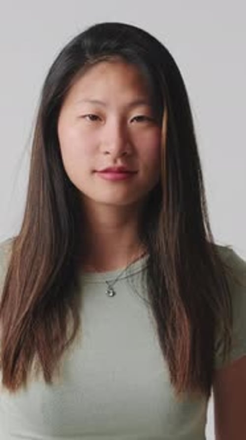 Young woman looking at camera smiling and laughing isolated over white background in studio