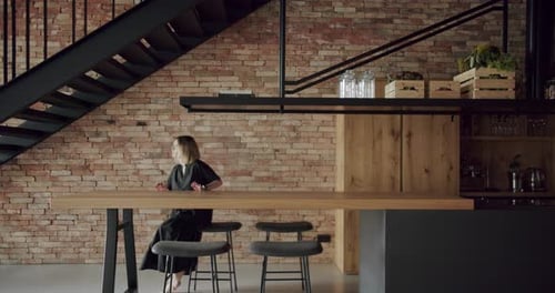 Blonde Woman Walks in Modern Kitchen