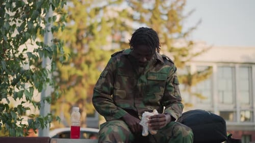 Soldat calme se relaxant dans le quartier Le personnel militaire du quartier repose sur un véhicule dans une banlieue tranquille