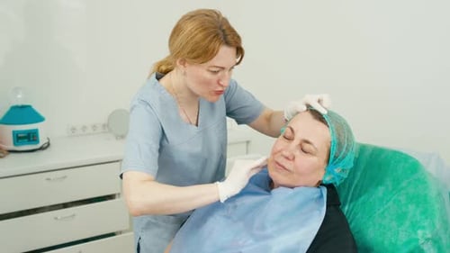Medical Professional Cleaning Woman's Face in Clinic