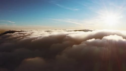 Soleil brillant au-dessus des nuages blancs duveteux au lever du soleil