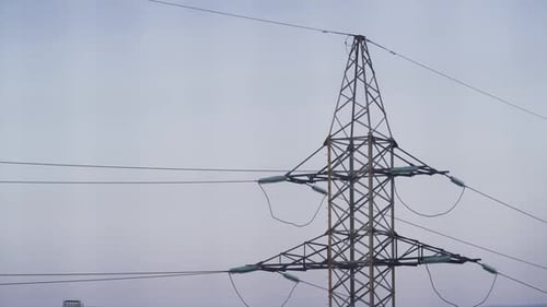 La torre de alta tensión transmite electricidad a través de un cielo azul claro