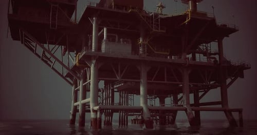 Oil Rig Standing Tall Over Calm Waters at Dusk with Clear Skies