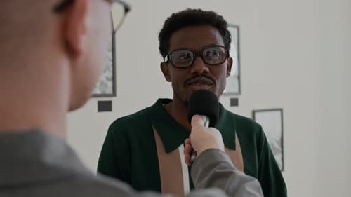 Mann interviewt lächelnden schwarzen Künstler