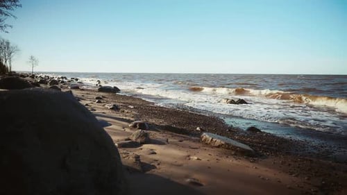 A Hazy Image of a Beach with Crashing Waves and a Windy Sky