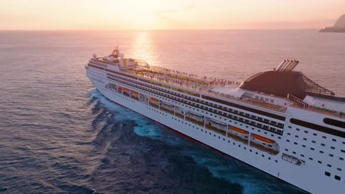 Cruise ship sailing through a vibrant sunset over the ocean for luxury travel