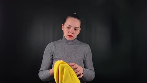 Uma mulher interagindo com um objeto isolado no fundo preto