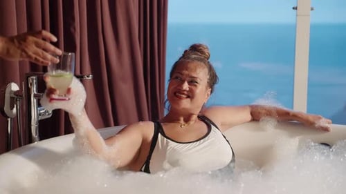 Woman Enjoying Luxurious Bath with Bubble and Drink