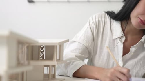 Architect using ruler to measure house model at modern office. Immaculate.